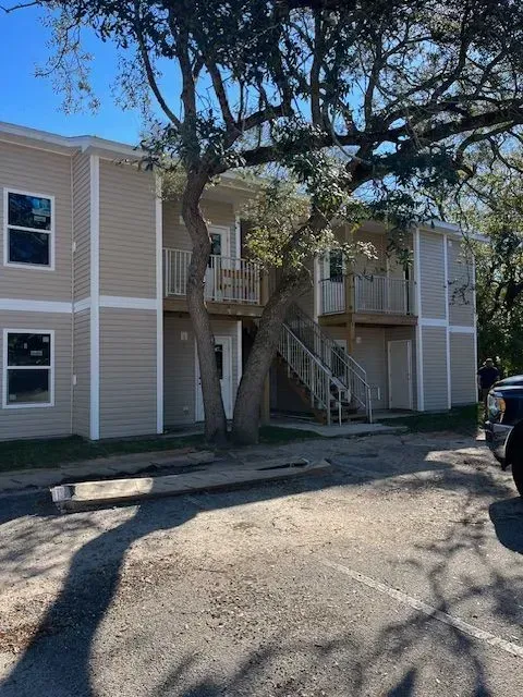 A building with stairs and a tree in front of it
