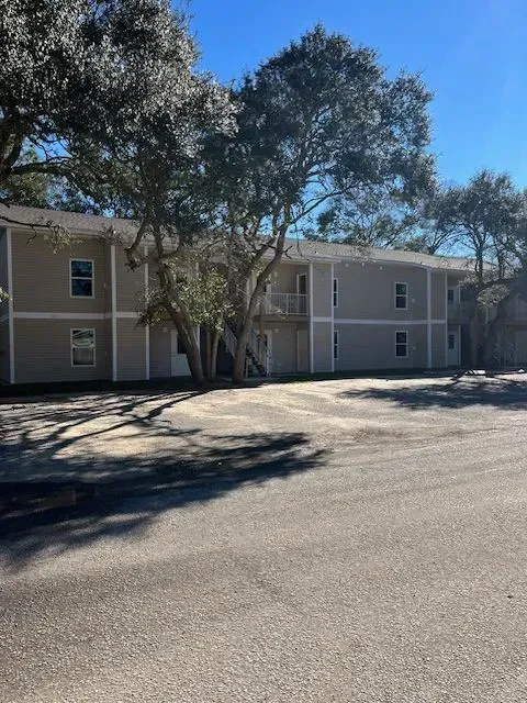A building with a lot of windows and trees in front of it.