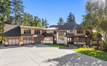 A large house with a lot of windows is surrounded by trees.