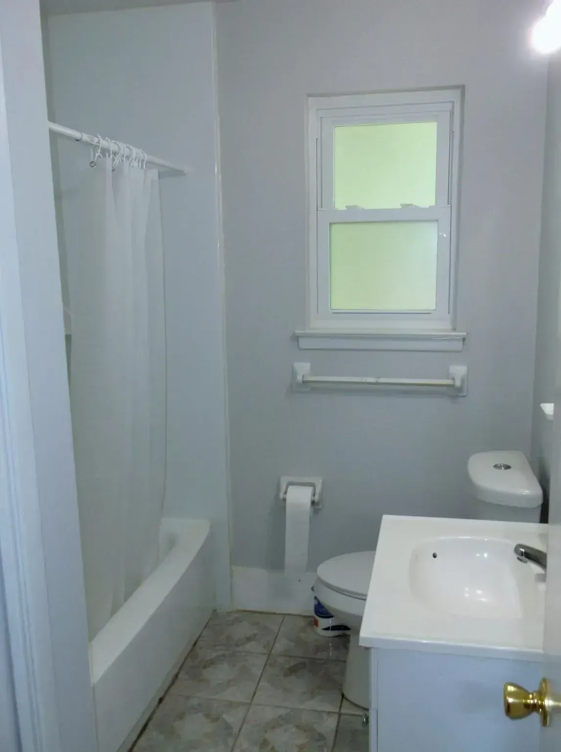 A bathroom with a toilet a sink and a window