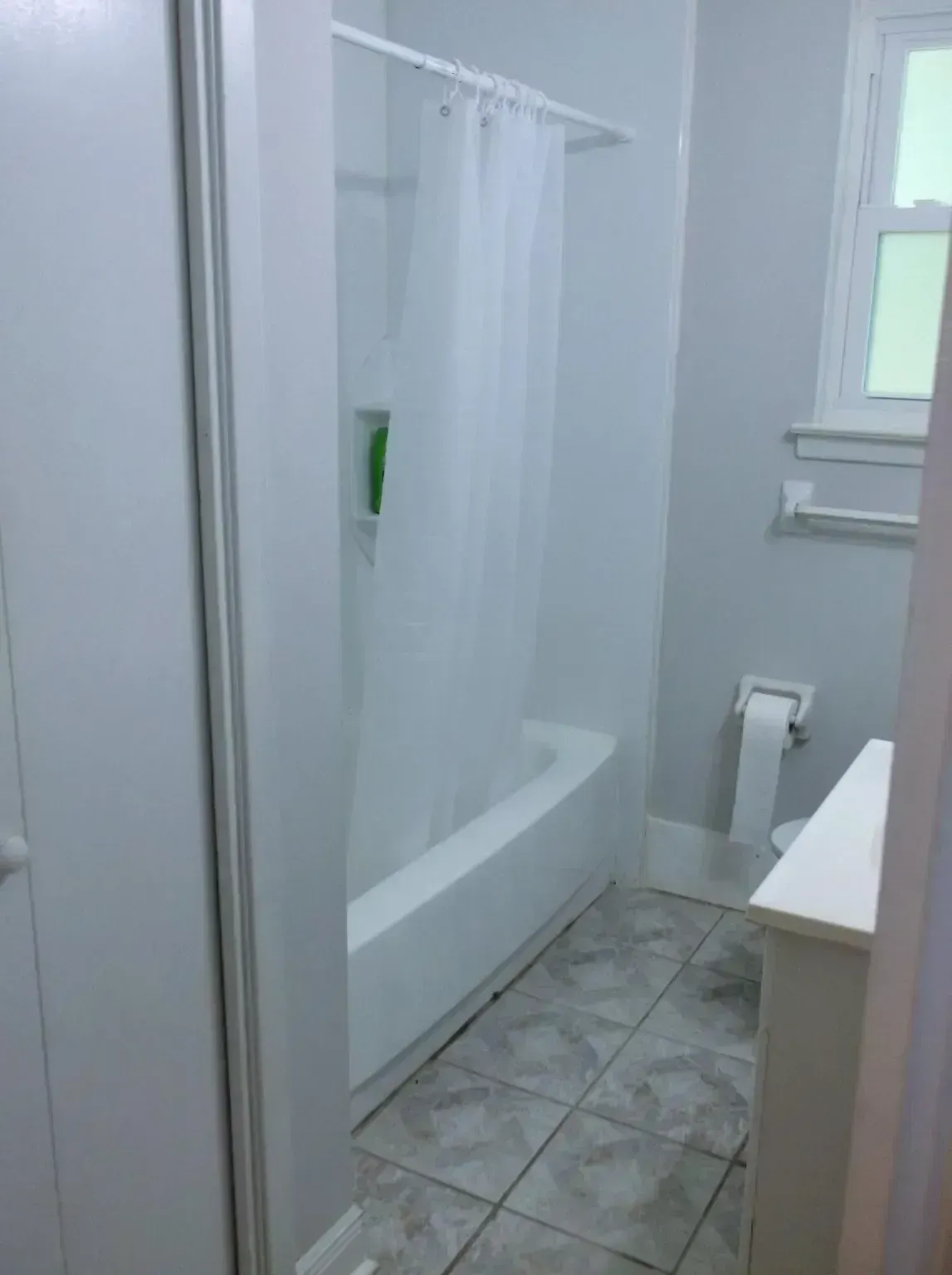 A bathroom with a bathtub , toilet , and shower curtain.