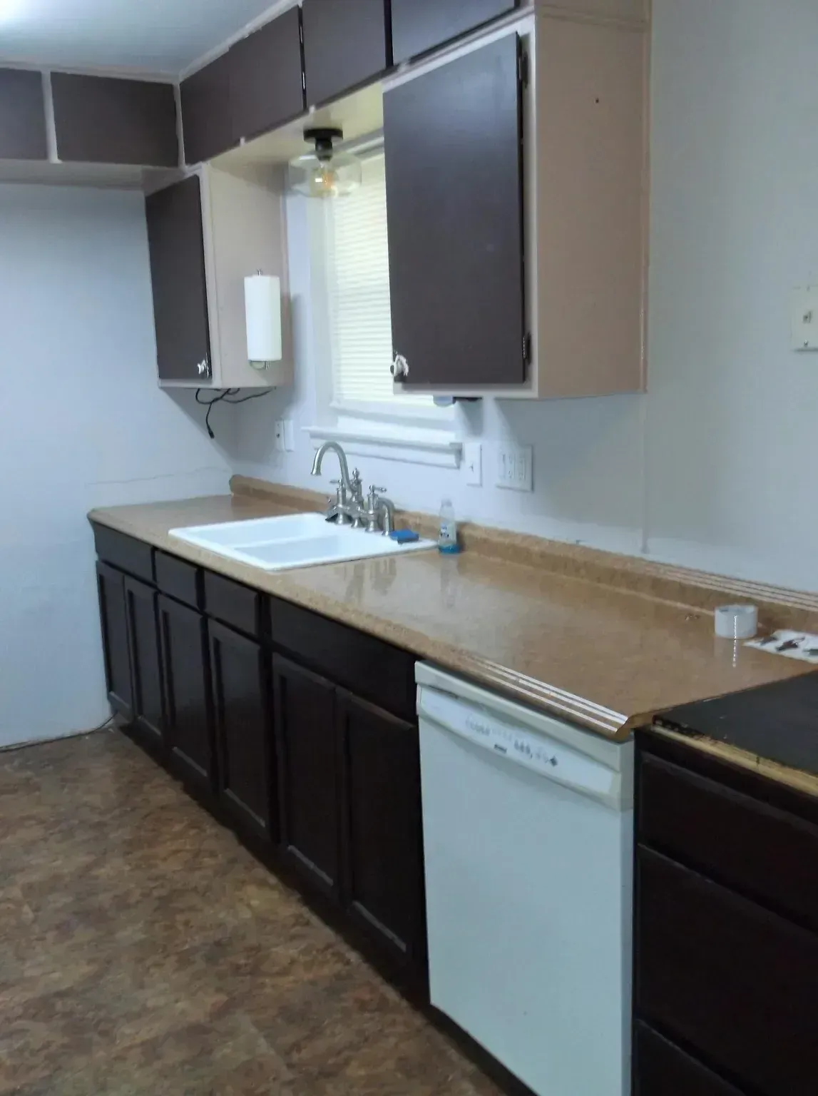A kitchen with brown cabinets and a white dishwasher