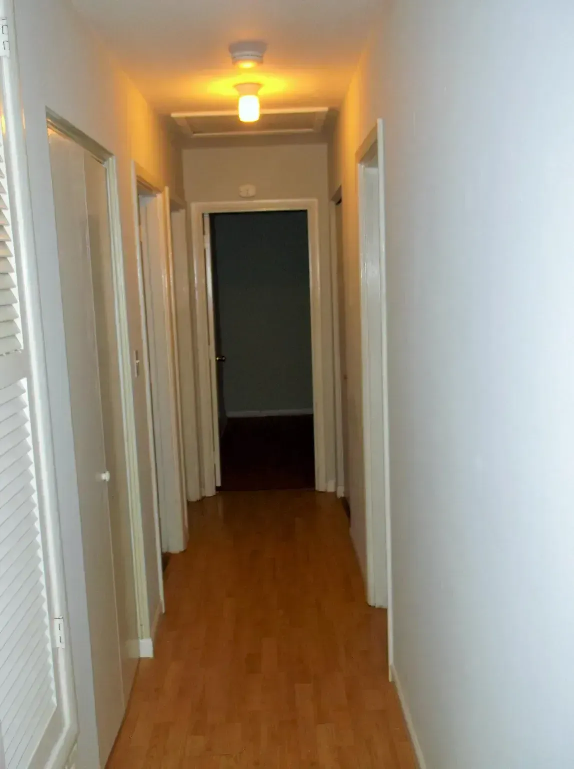 A hallway with wooden floors and white walls