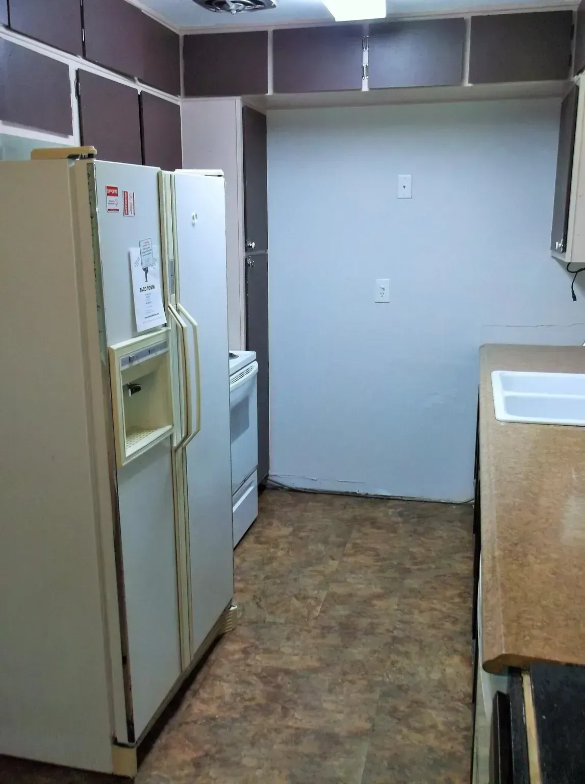 A kitchen with a refrigerator , stove and sink.
