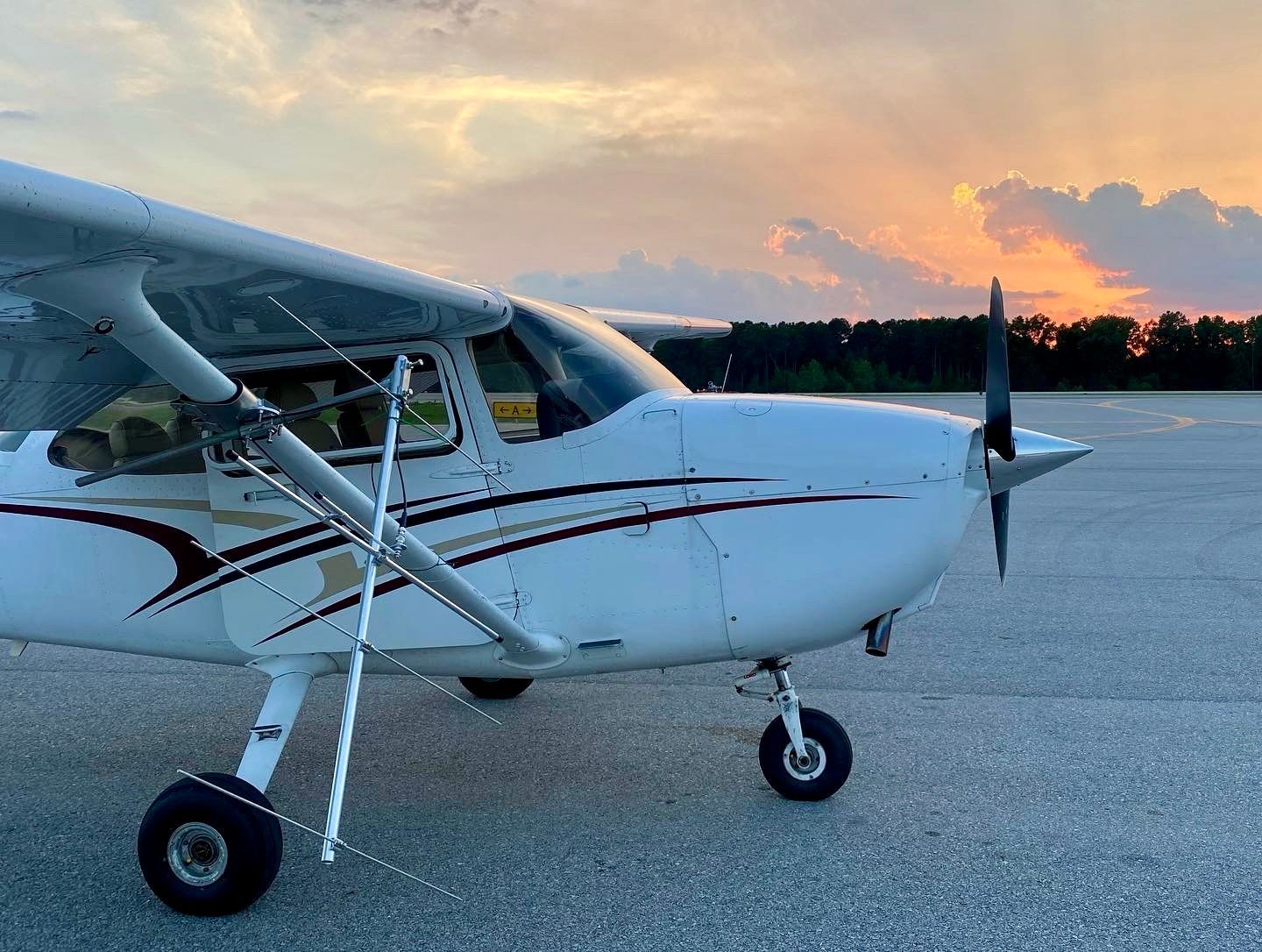 Image of a radio telemetry antenna affixed to the wing of a small airplane with a sunset in the background.