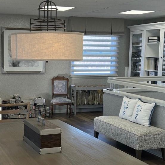 A commercial space with a couch, chairs, tables and a tree.