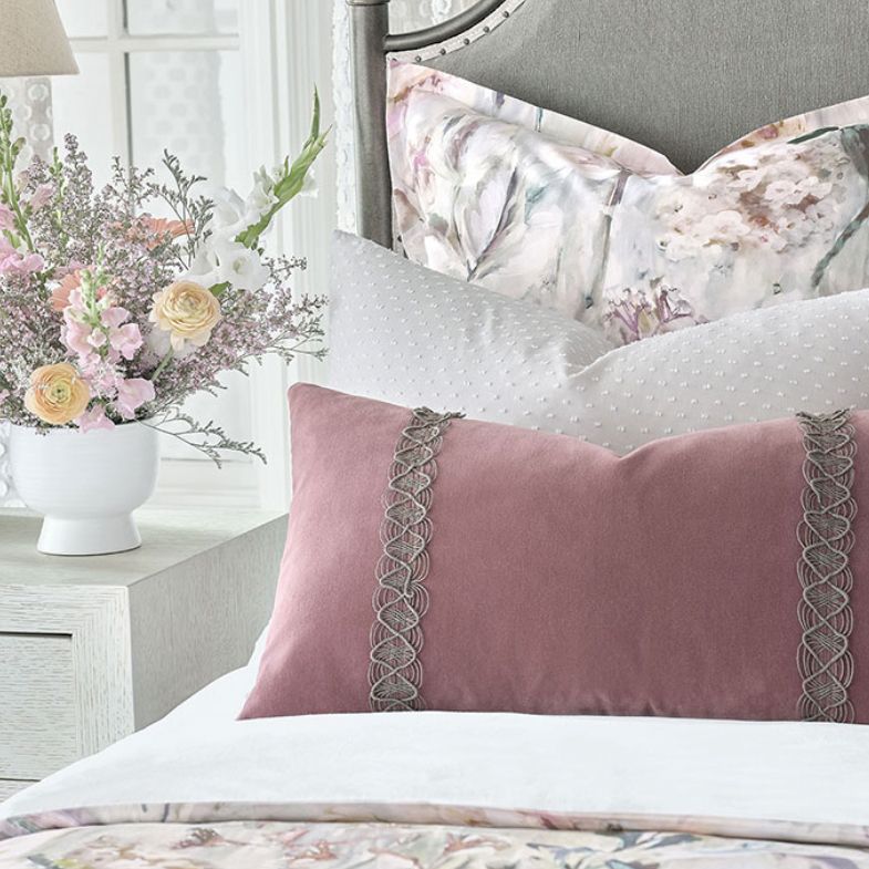 A bedroom with a bed, nightstands, and lamps.