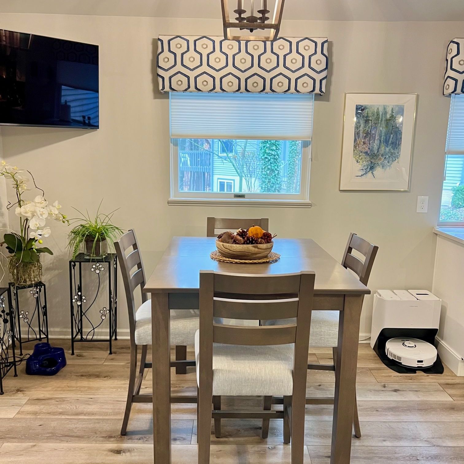 A kitchen with a large island, sink, stove and stainless steel appliances and window treatments.