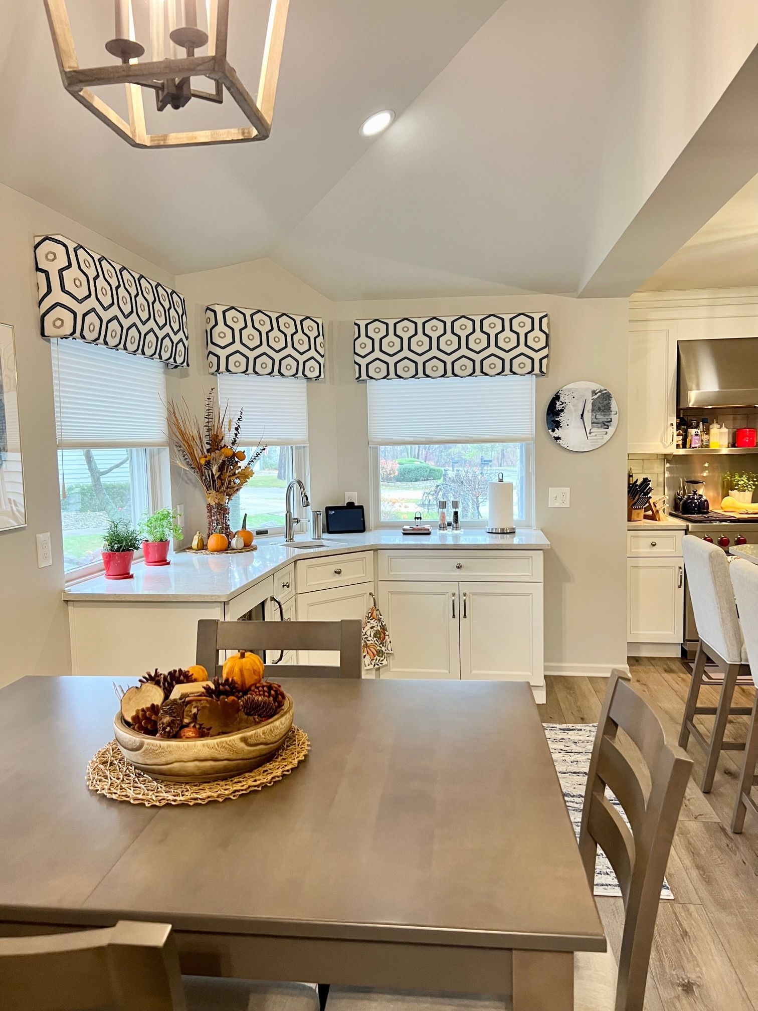 A dining room table with window treatments.