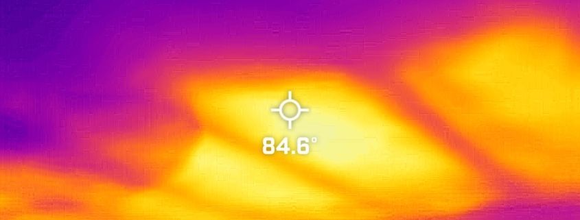 A thermal image of a purple and orange background with a compass pointing to the sun