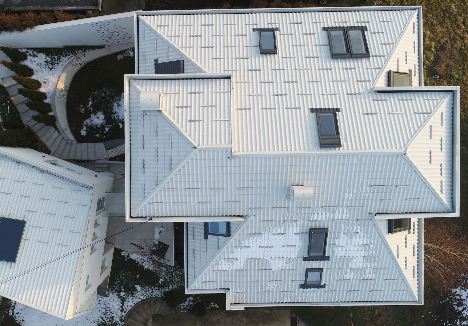 An aerial view of a white house with a lot of windows