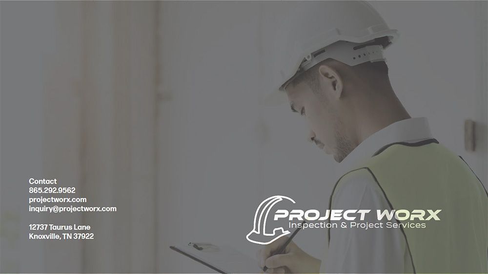 A man wearing a hard hat is writing on a clipboard.