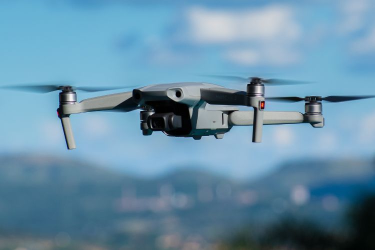 A drone is flying in the sky over a mountain range