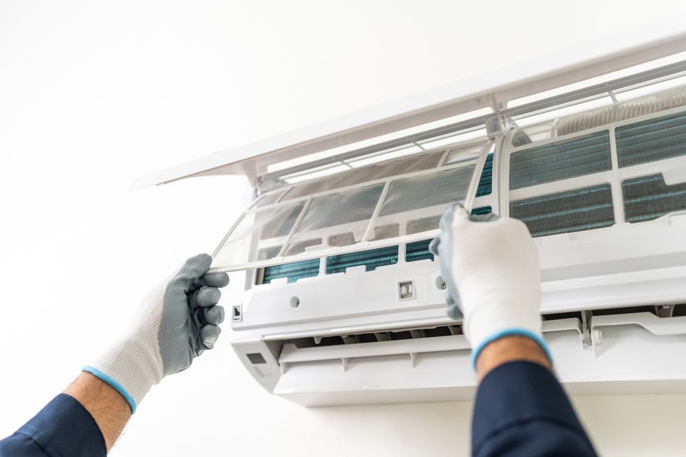 Man Replacing An Air Conditioner Filter