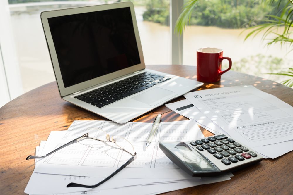Laptop, Documents, Calculator, Eyeglasses, and Coffee Cup — NQ Business Advisers in Jensen, QLD
