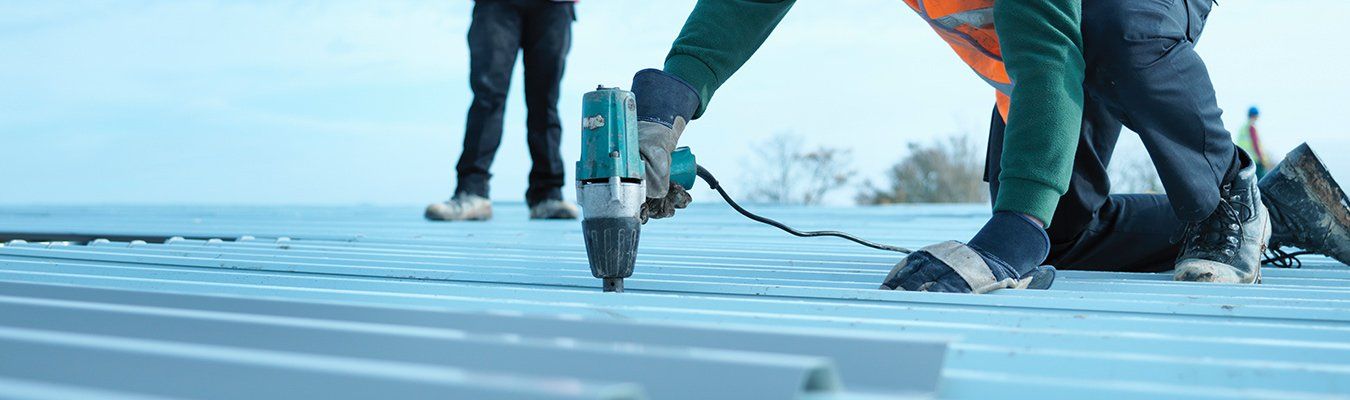 A group of construction workers are working on a roof.