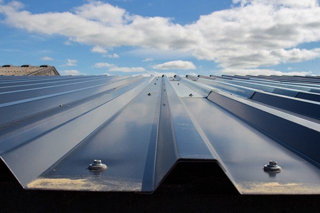 A blue metal roof with a blue sky in the background