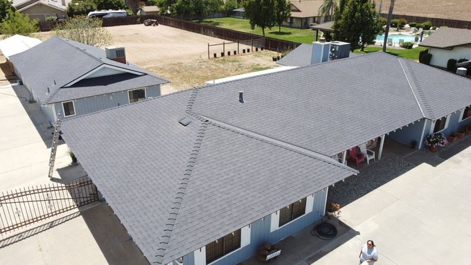 An aerial view of a house with a gray roof