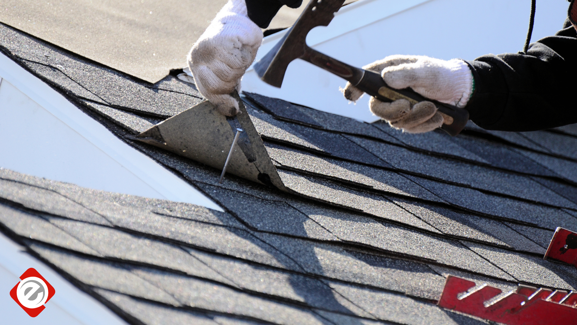 Person using a hammer to repair roof shingles. White gloves, close-up shot.