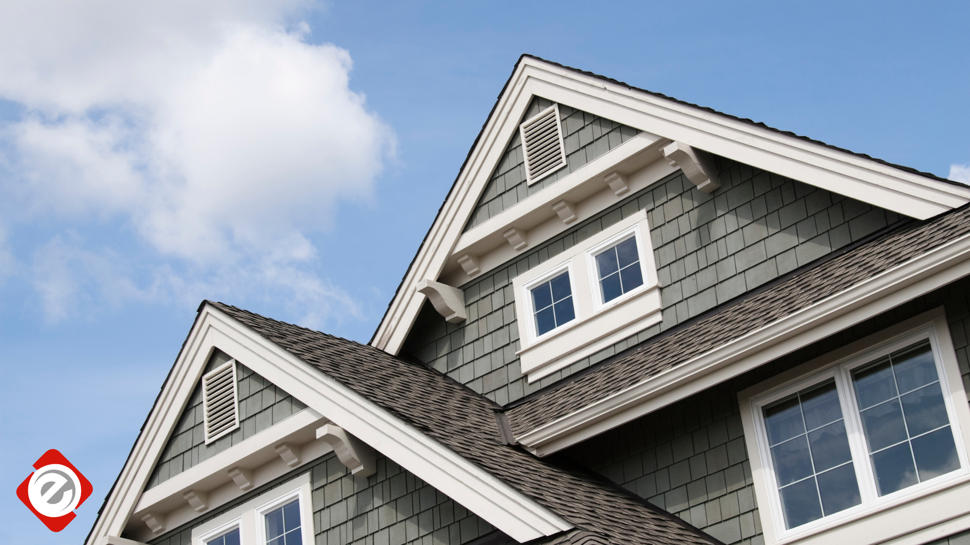 House exterior with gray siding, white trim, and a blue sky.