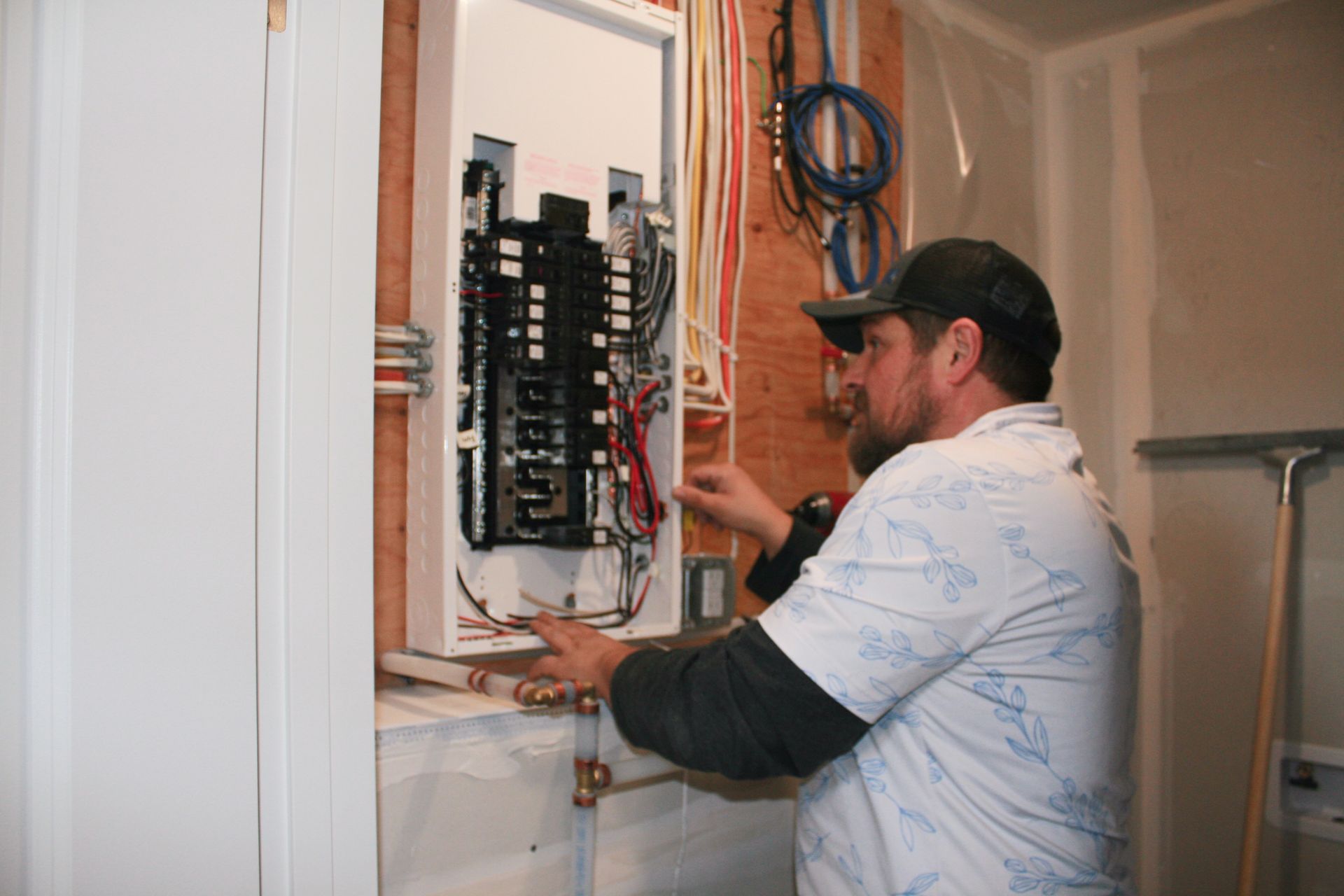 A man is working on an electrical panel in a room.