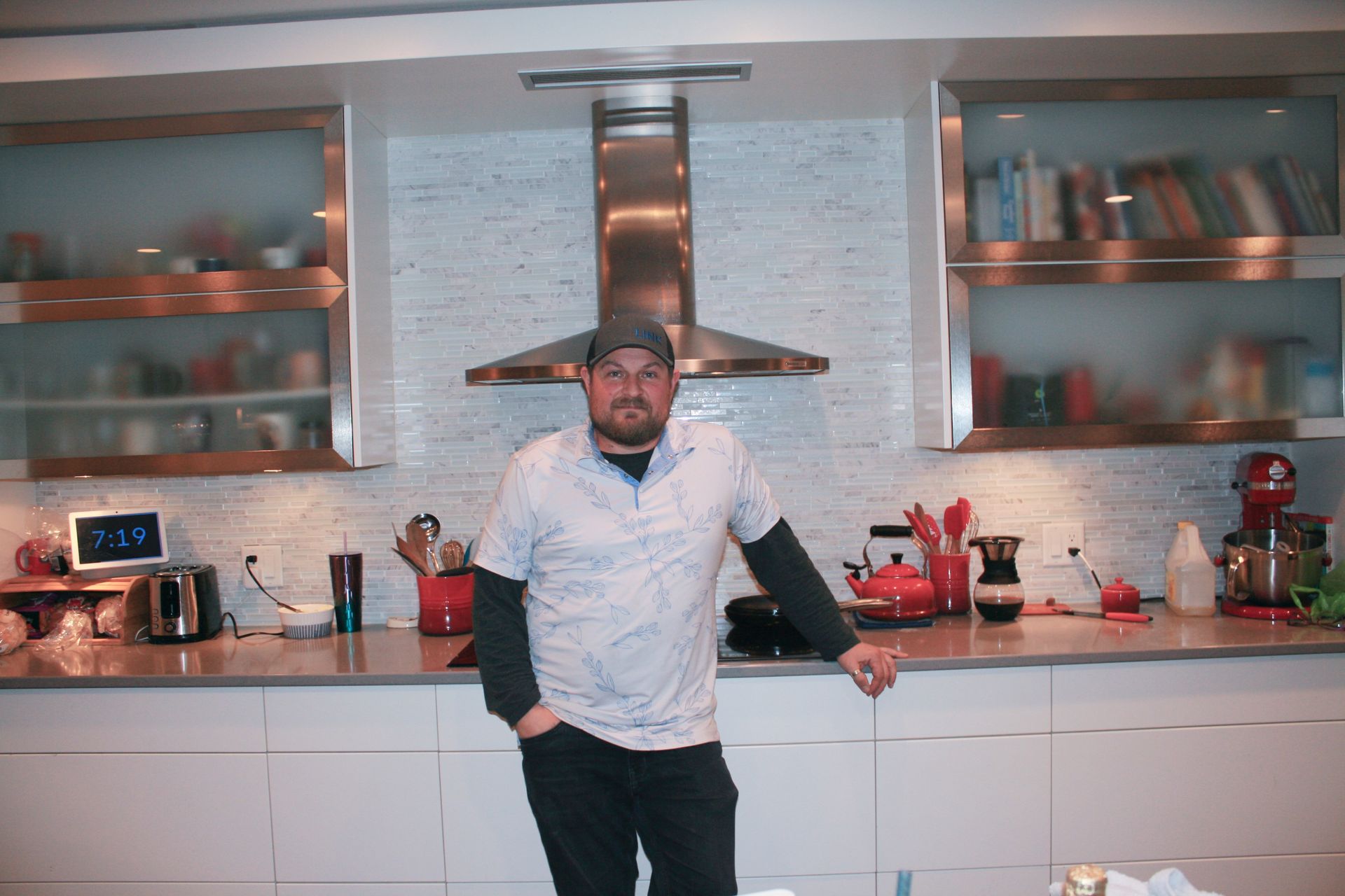 A man standing in a kitchen with his hands in his pockets