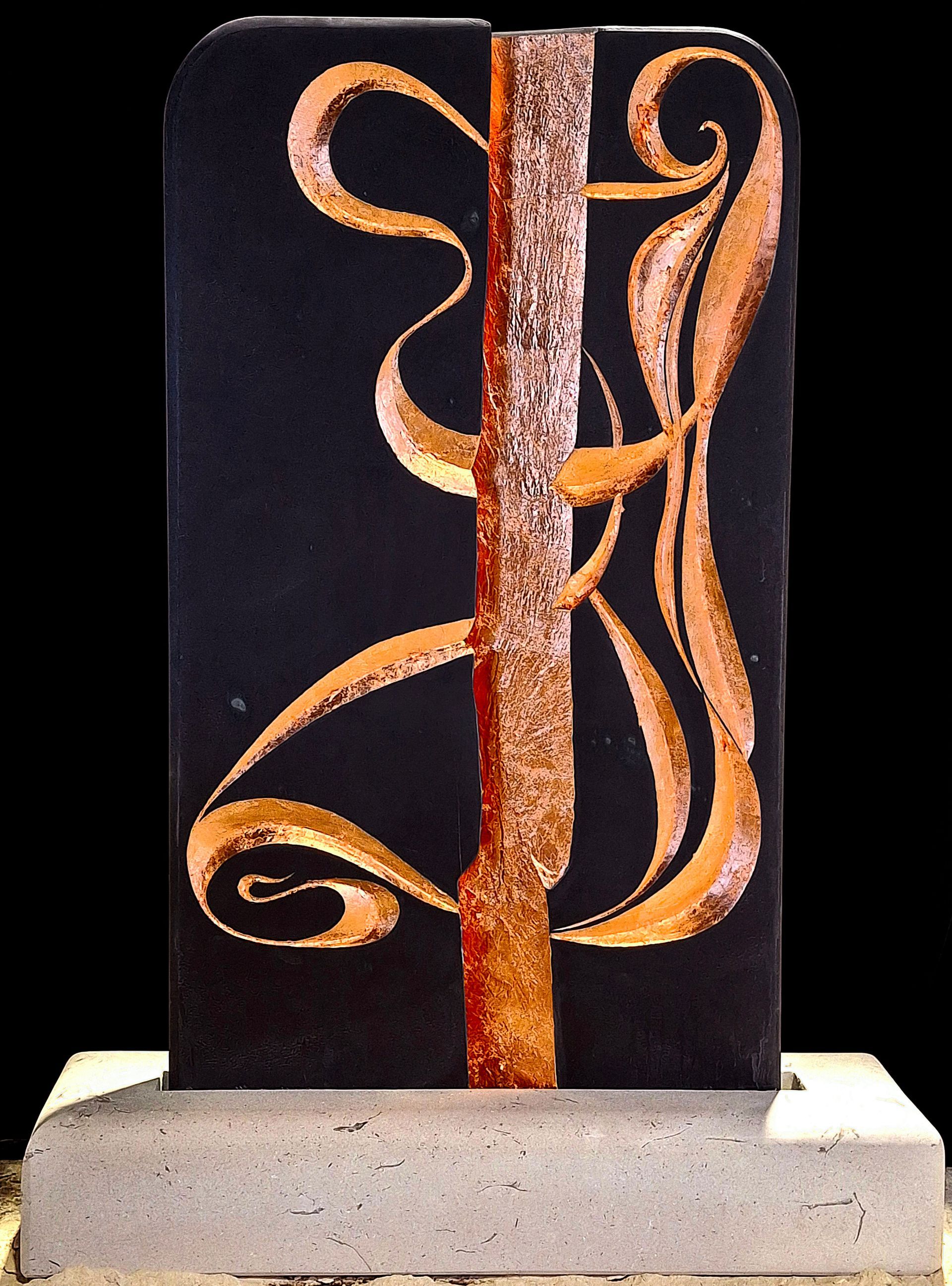 A black and gold sculpture with the letter j on it