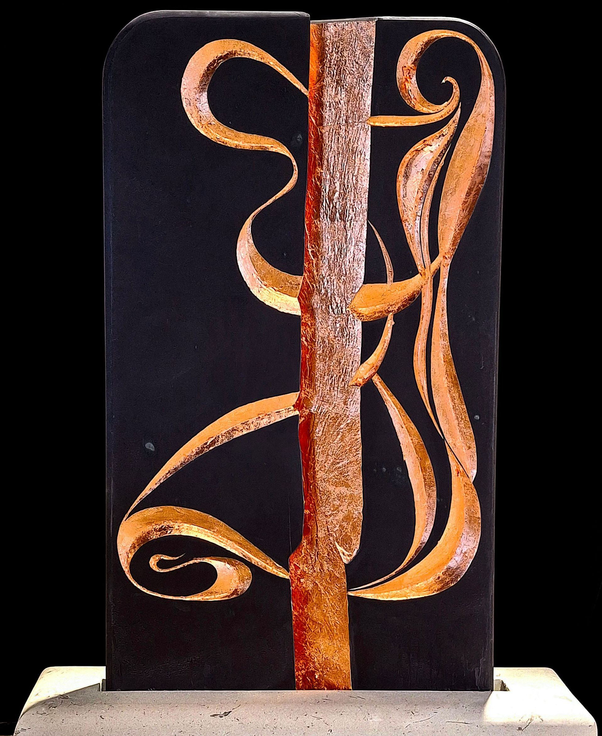 A black and gold sculpture with the letter j on it