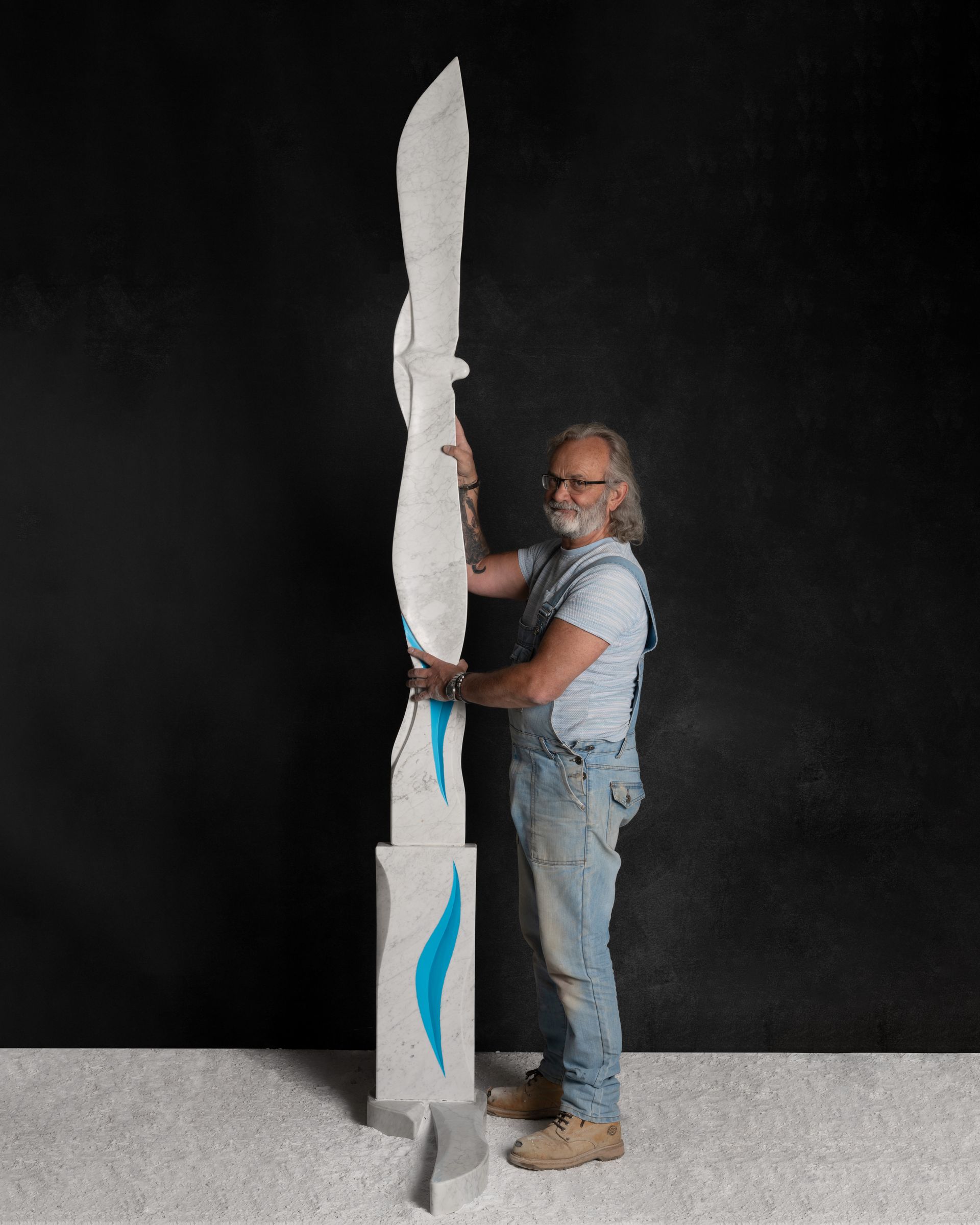 A man is standing next to a large white sculpture