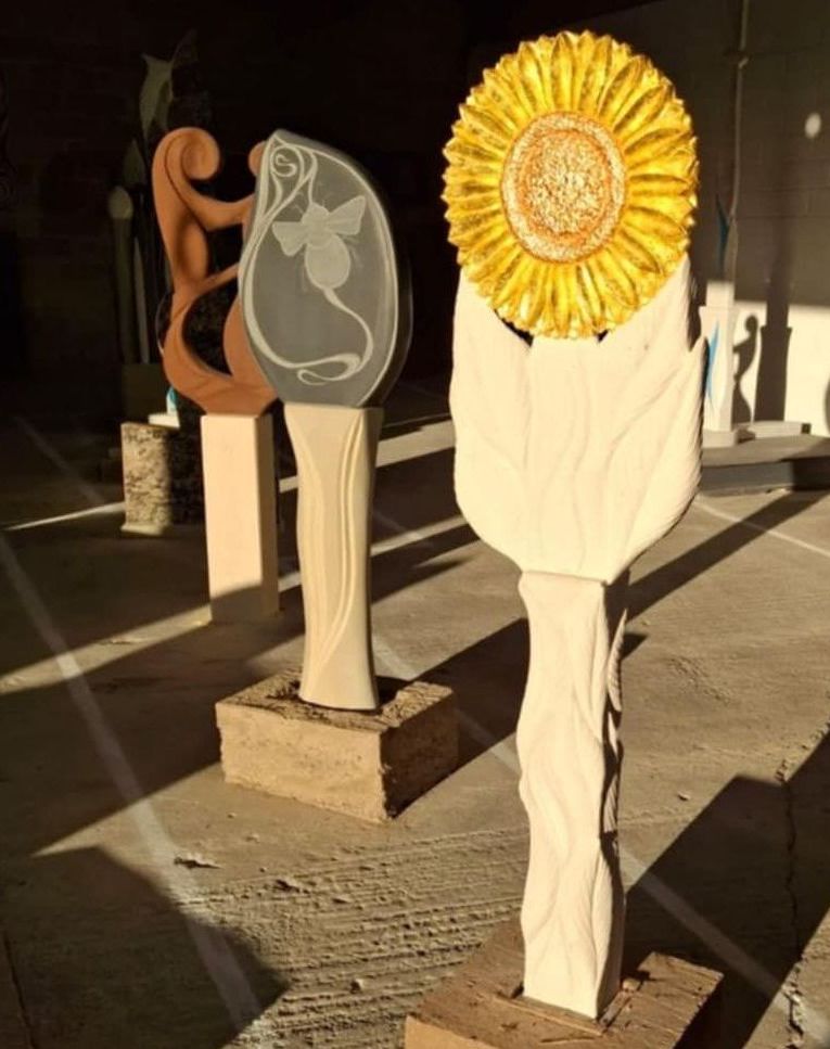 A statue of a sunflower is sitting next to another statue