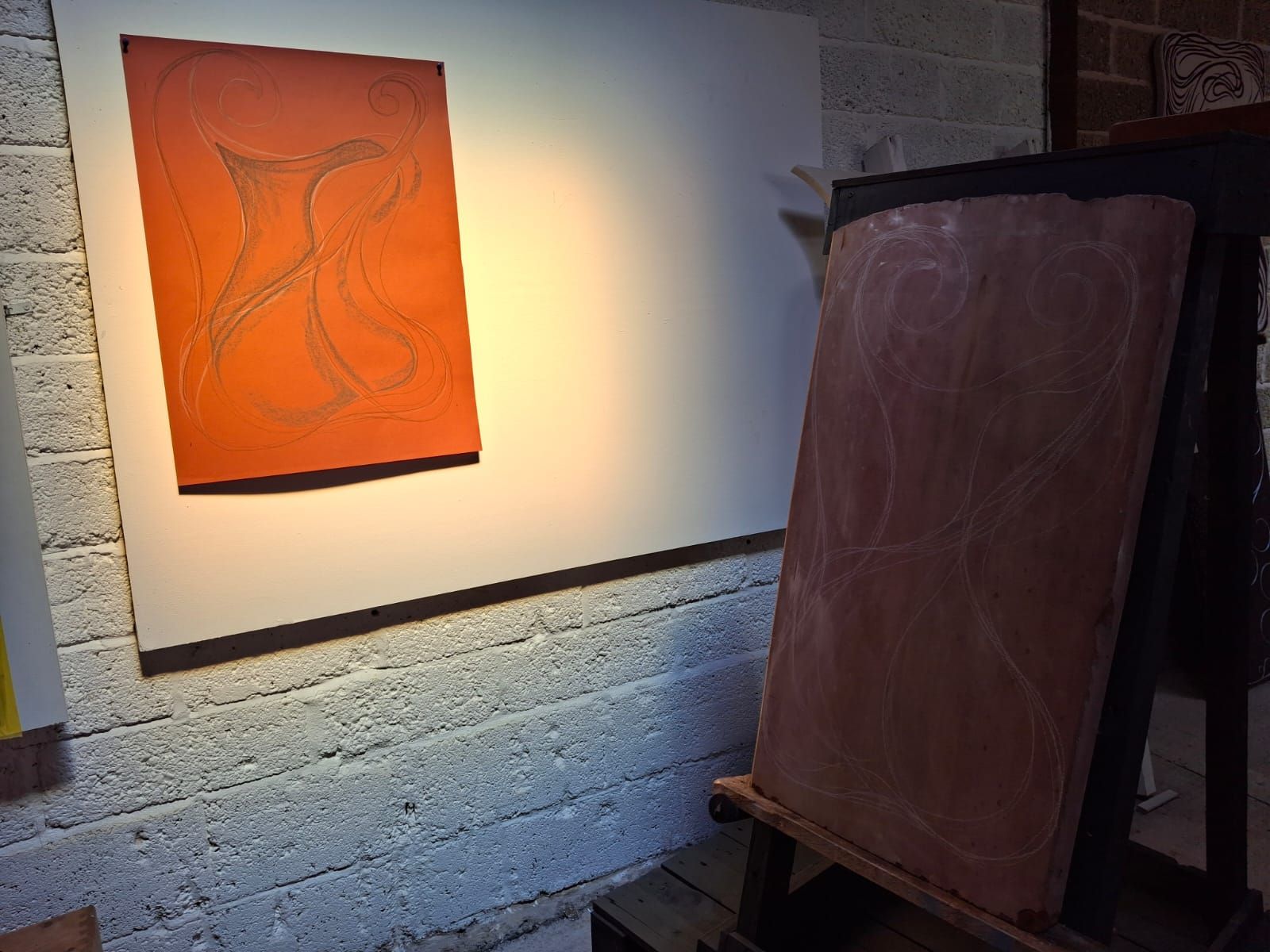 A painting is hanging on a wall next to a wooden easel