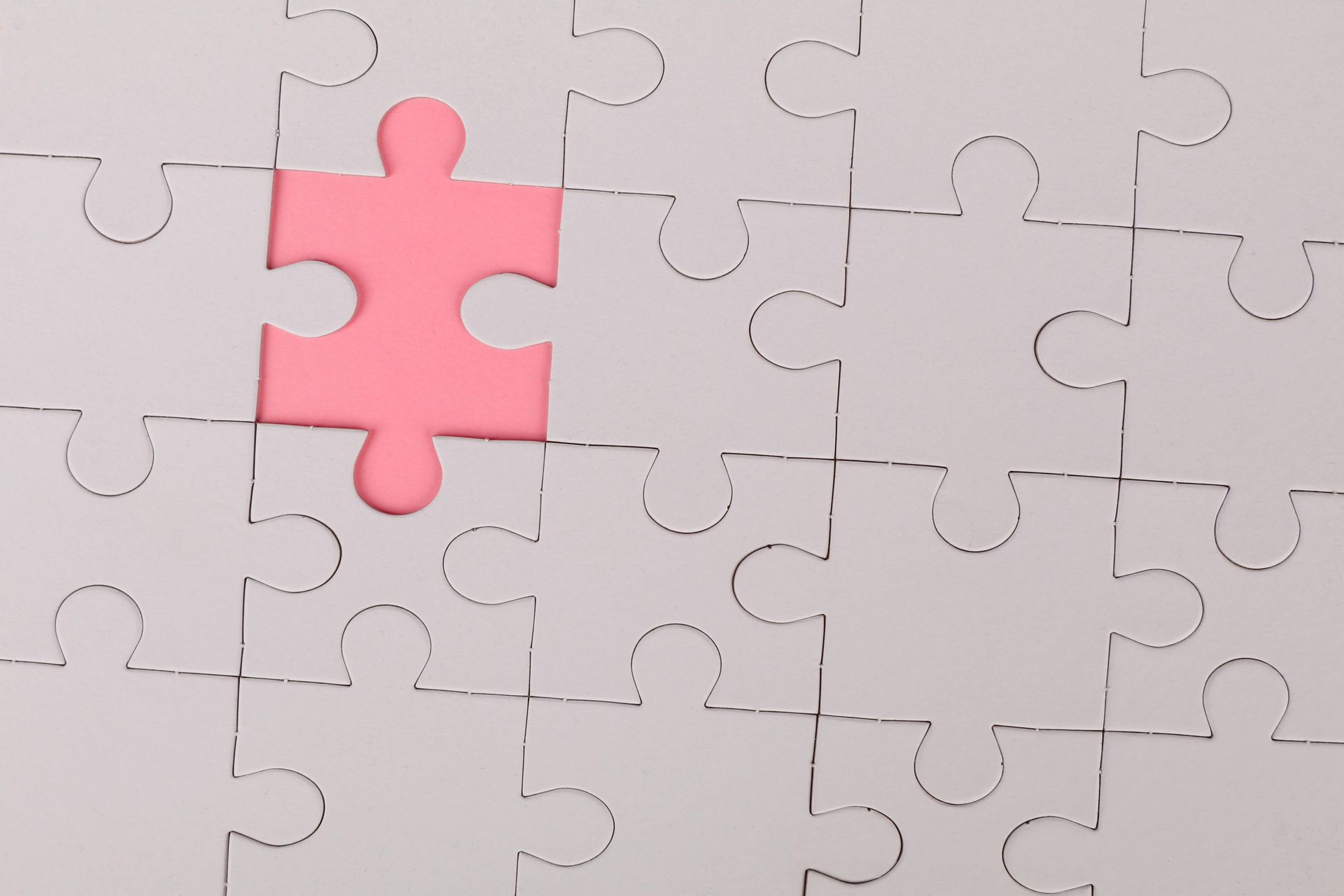 Puzzle with one puzzle piece missing showing pink background