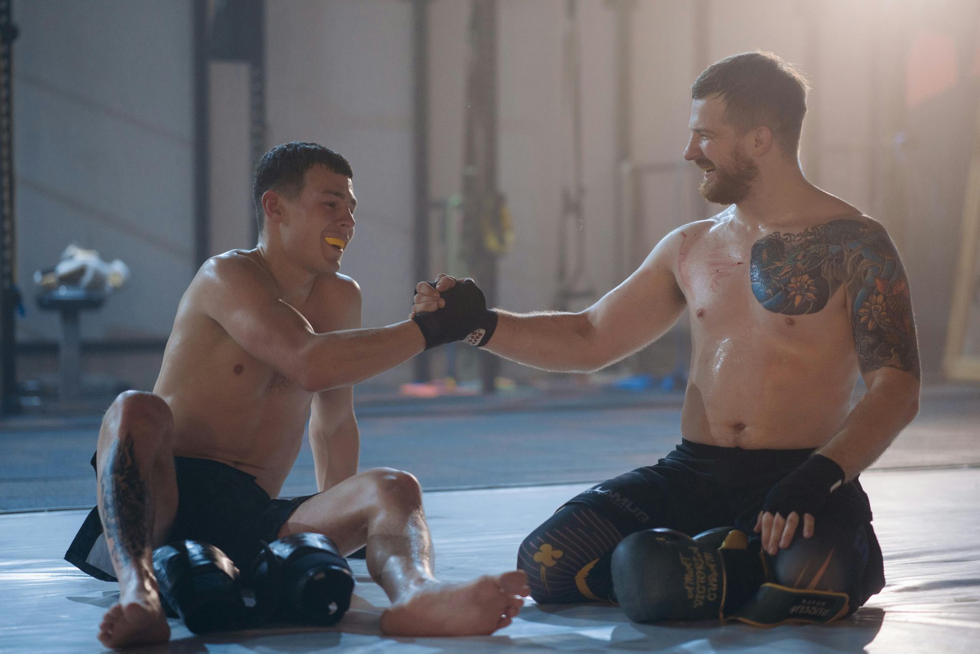 Two men with boxing gloves fistbumping