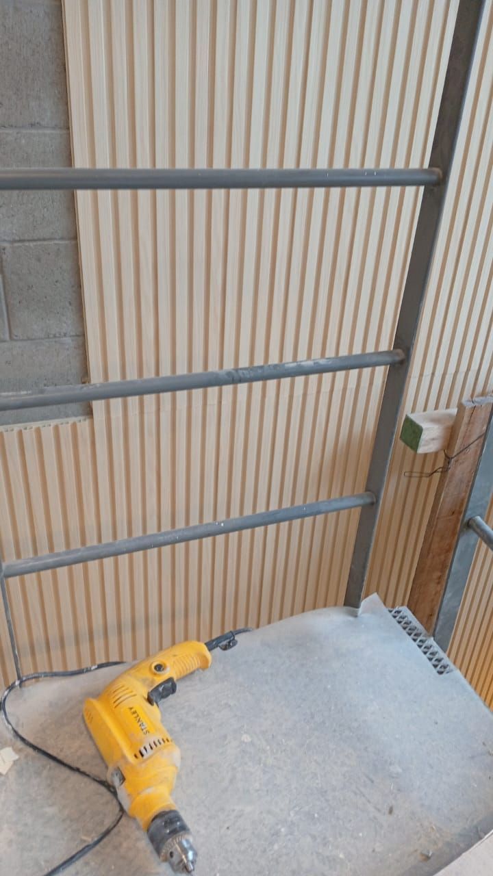 Casa de ladrillo de dos plantas en construcción con porche cubierto y ventanas abiertas.