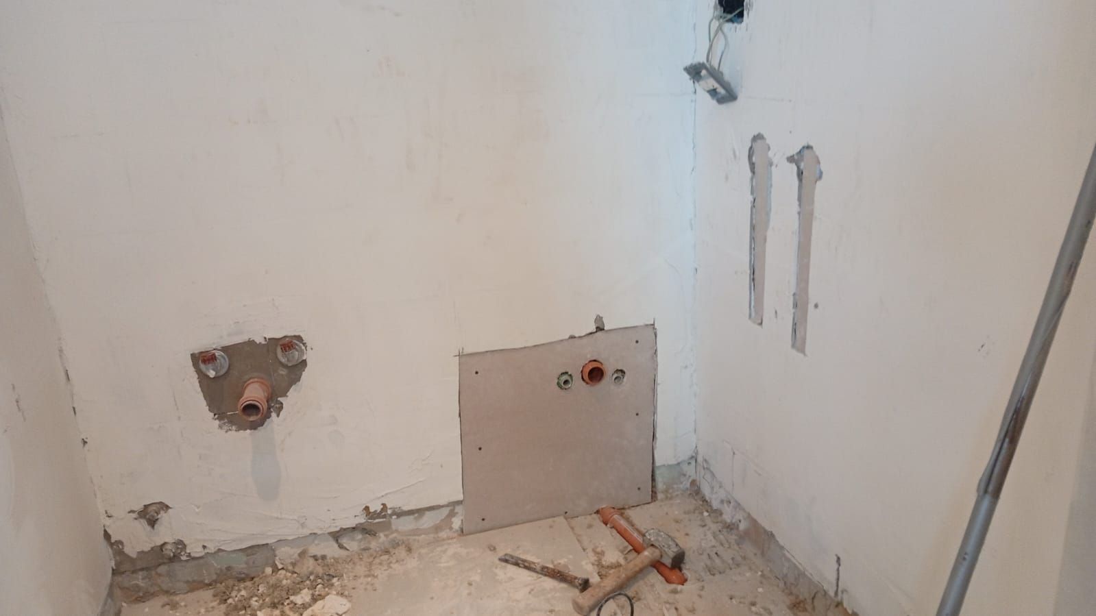 Moderna casa de dos pisos con puerta de madera por la noche, escalones iluminados y un pequeño árbol.