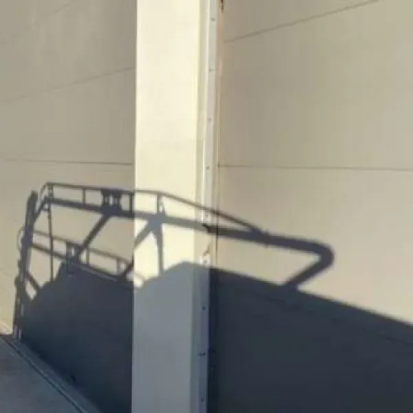 Shadow of a vehicle's framework cast on a beige building wall. Sunny, outdoor setting.