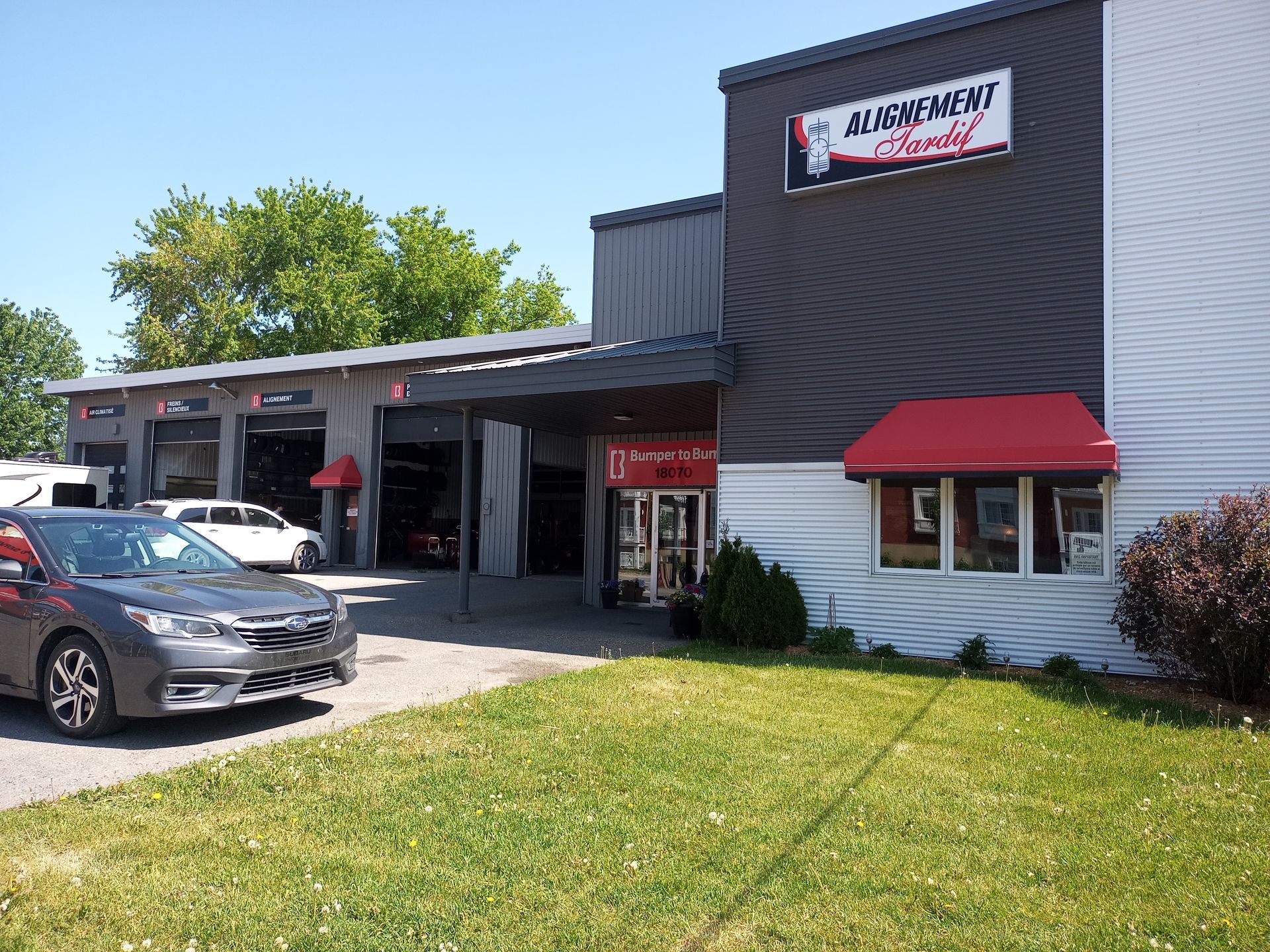 Une voiture est garée devant un bâtiment avec un auvent rouge