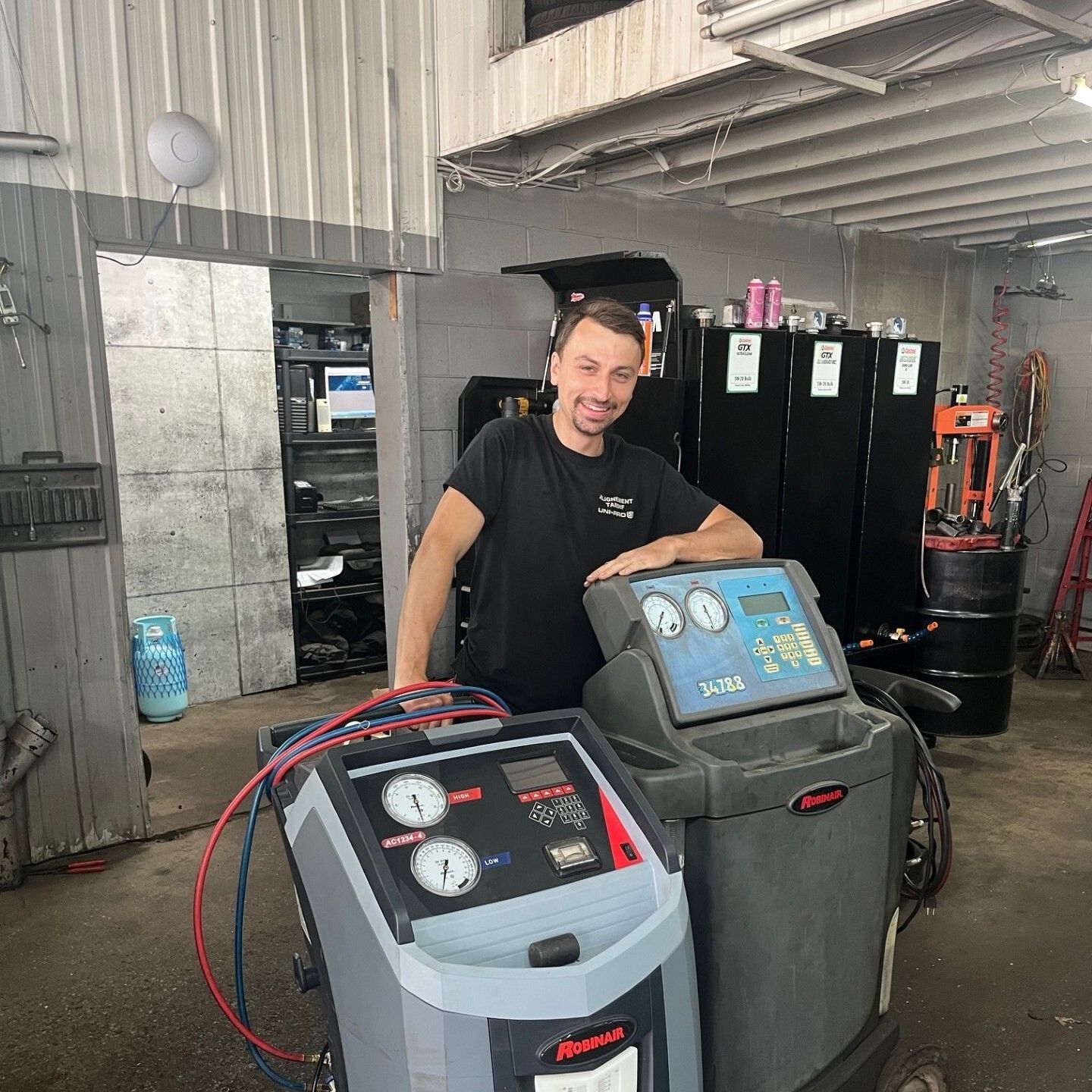 Un homme se tient à côté d'une machine dans un garage.