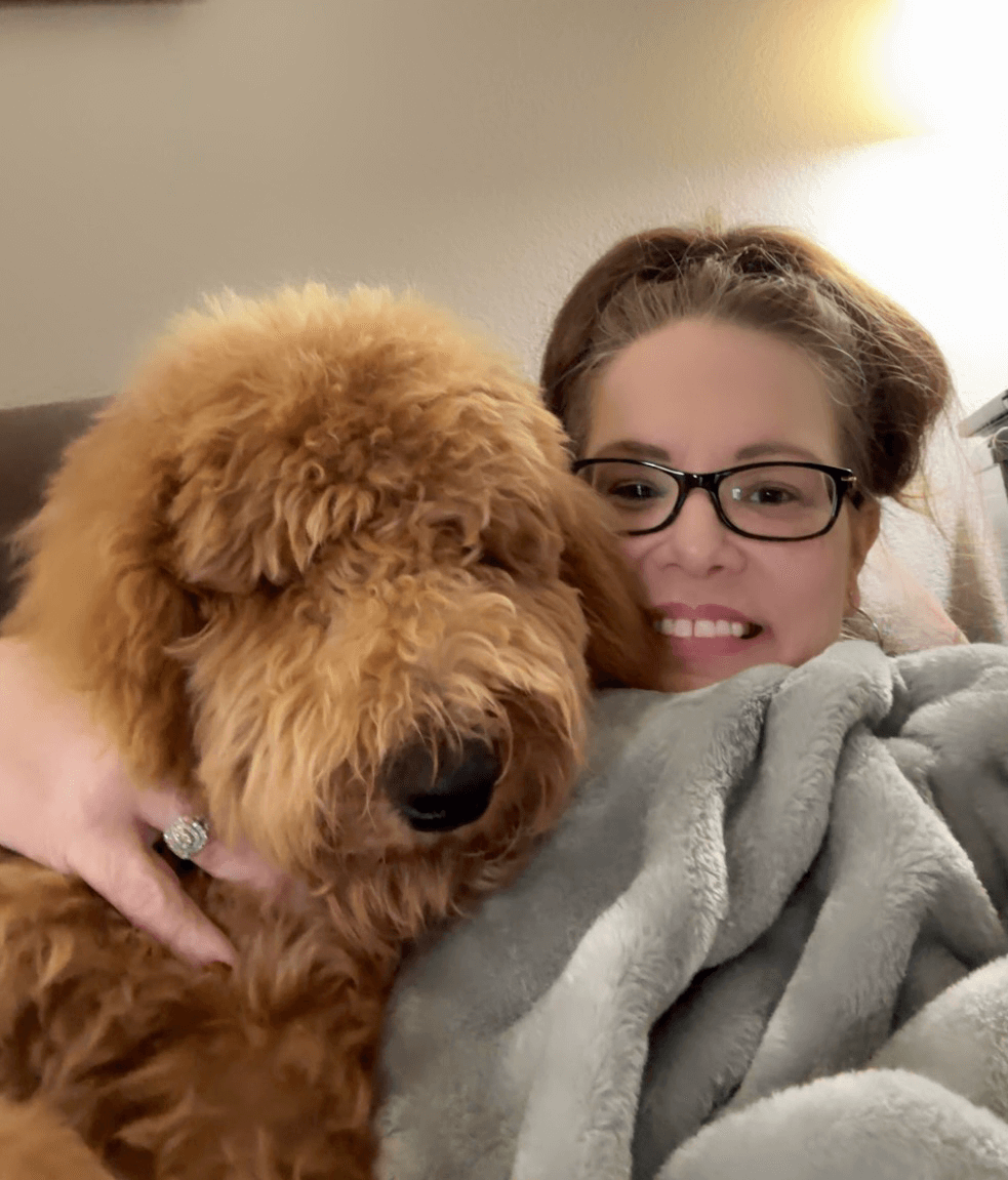 Jennifer Greenfield, Burleson TX Realtor, relaxing at home with her fluffy dog while taking a break from real estate work.