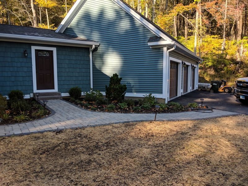 A blue house with a car parked in front of it
