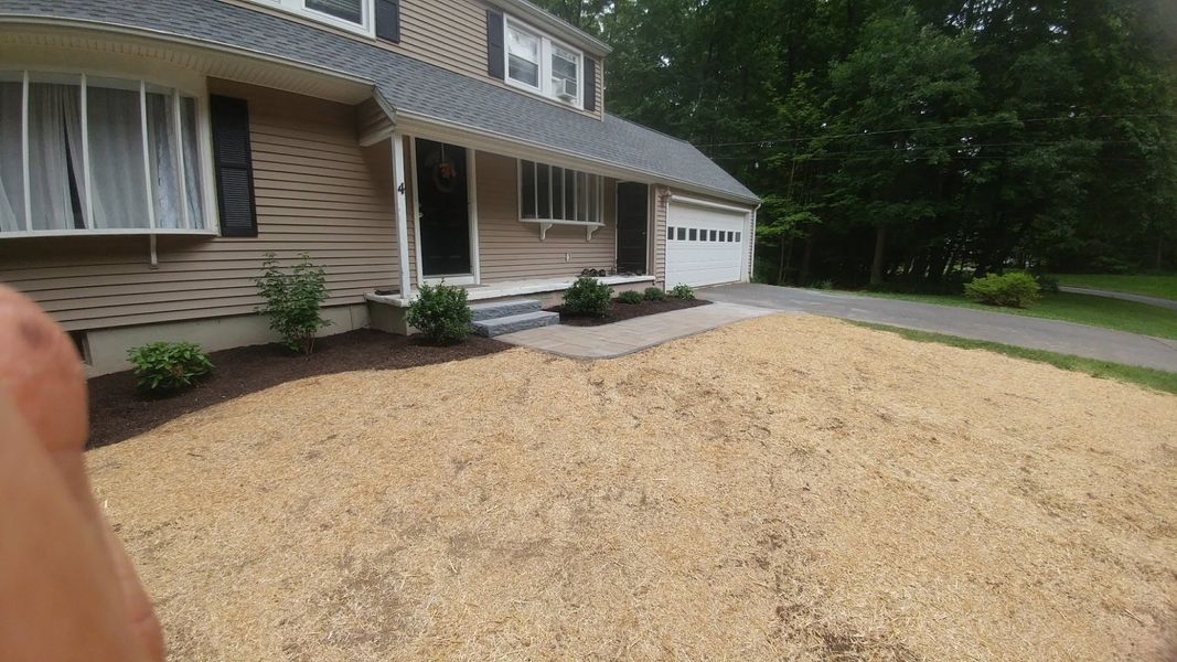 A person is standing in front of a house with a lot of dirt in front of it.