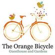 Orange bicycle logo with bird and fruit, reading “The Orange Bicycle Guesthouse and Gardens”