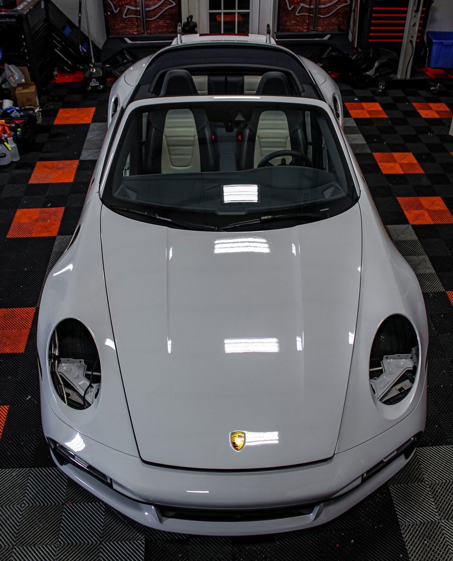 A white sports car is parked in a garage