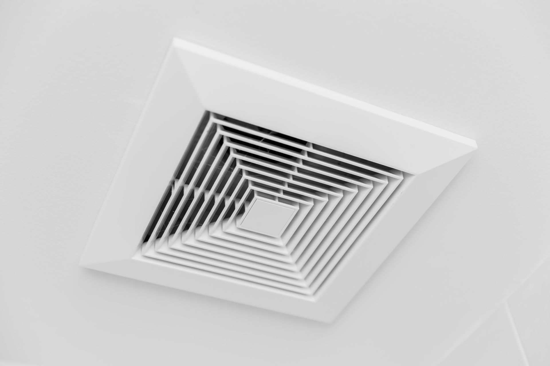 A white square air vent is hanging from the ceiling.