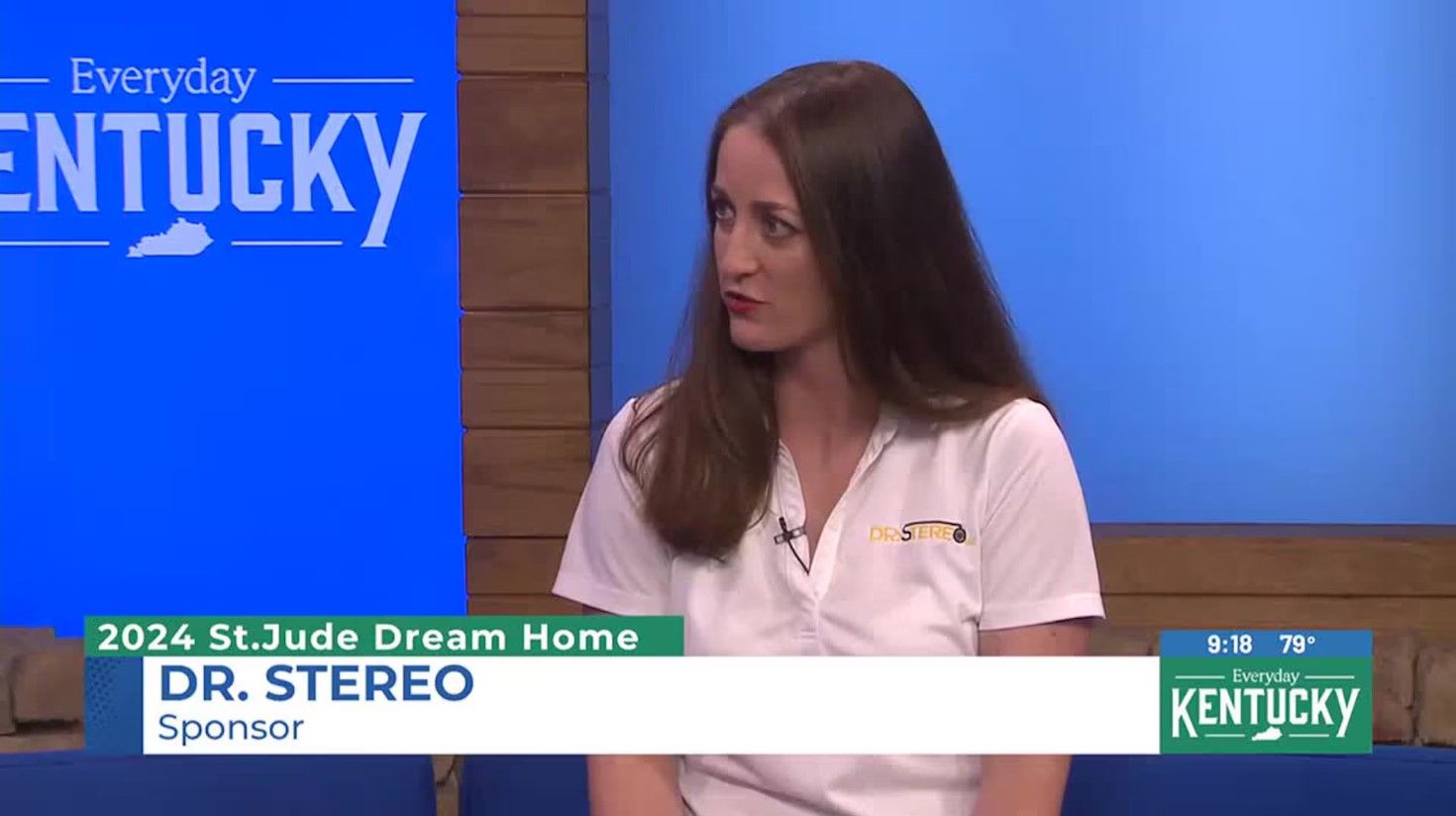 A woman is sitting on a couch in front of a sign that says kentucky