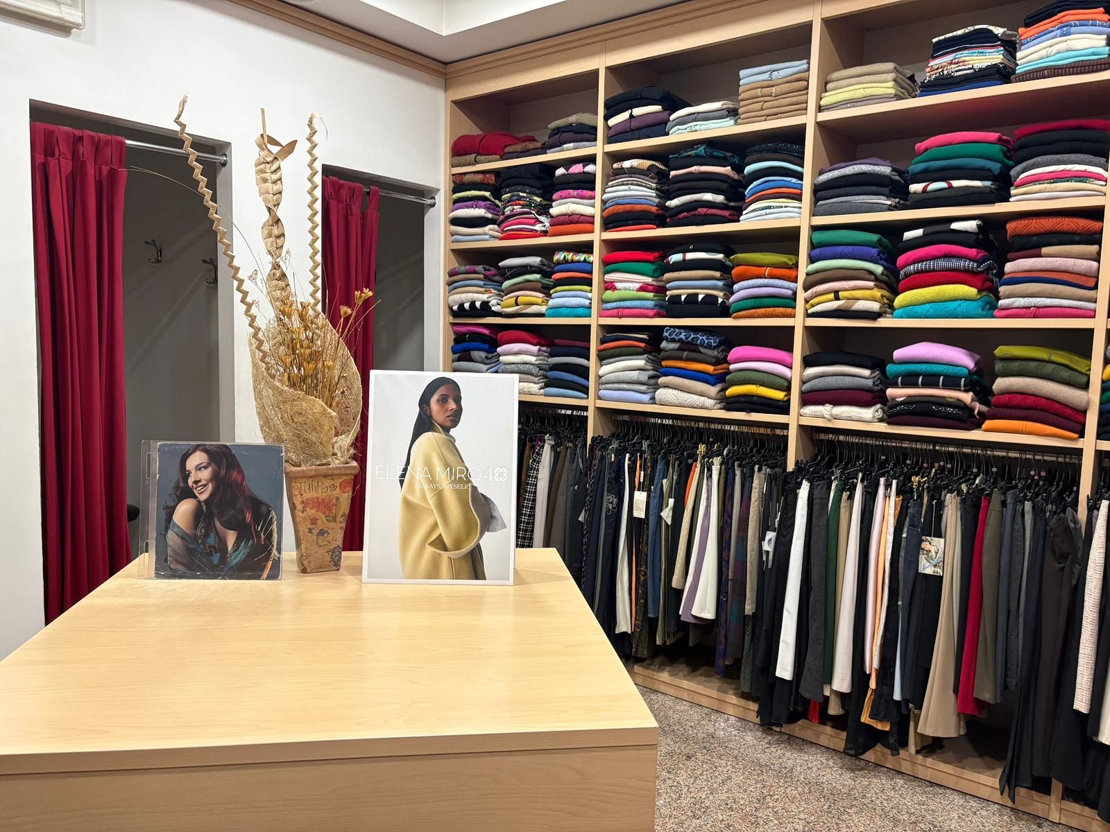 Interno di un negozio di abbigliamento con vestiti impilati sugli scaffali,