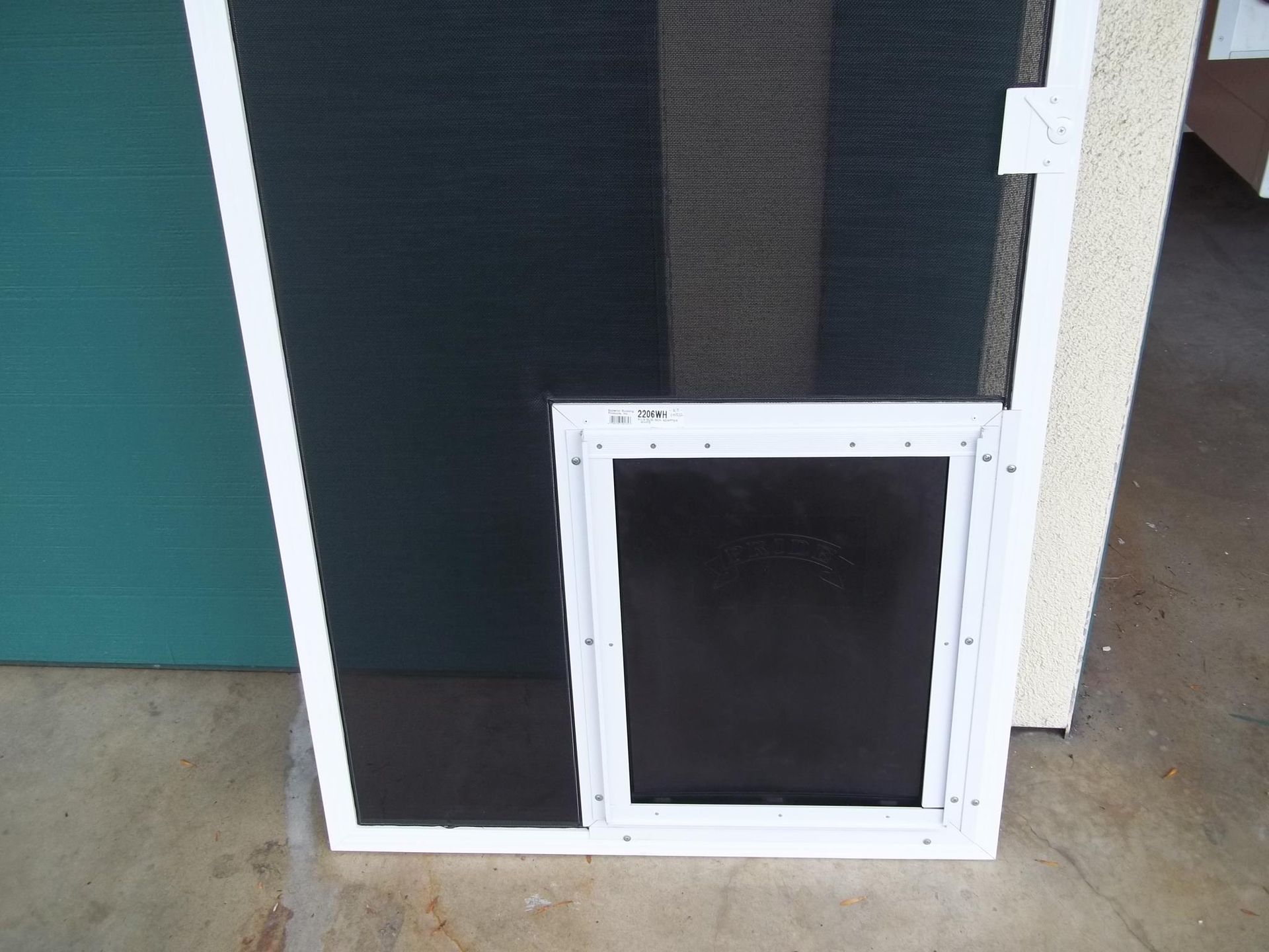A screen door with a dog door attached to it