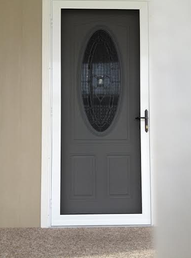 A black door with a glass window is sitting on a carpeted floor.
