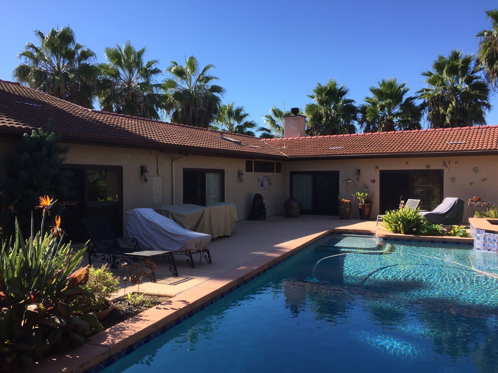 A house with a large swimming pool in front of it