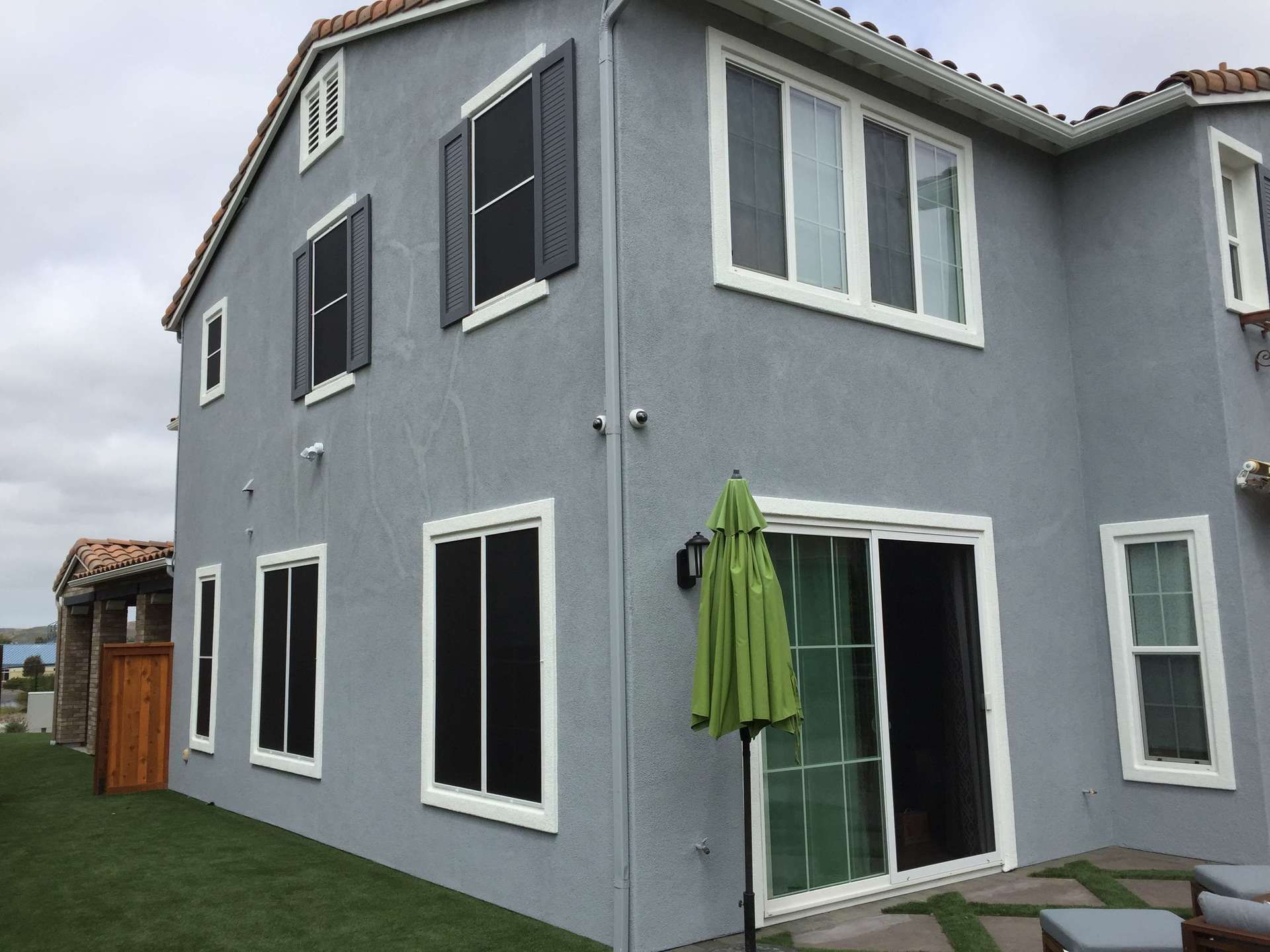 A large house with a green umbrella in front of it